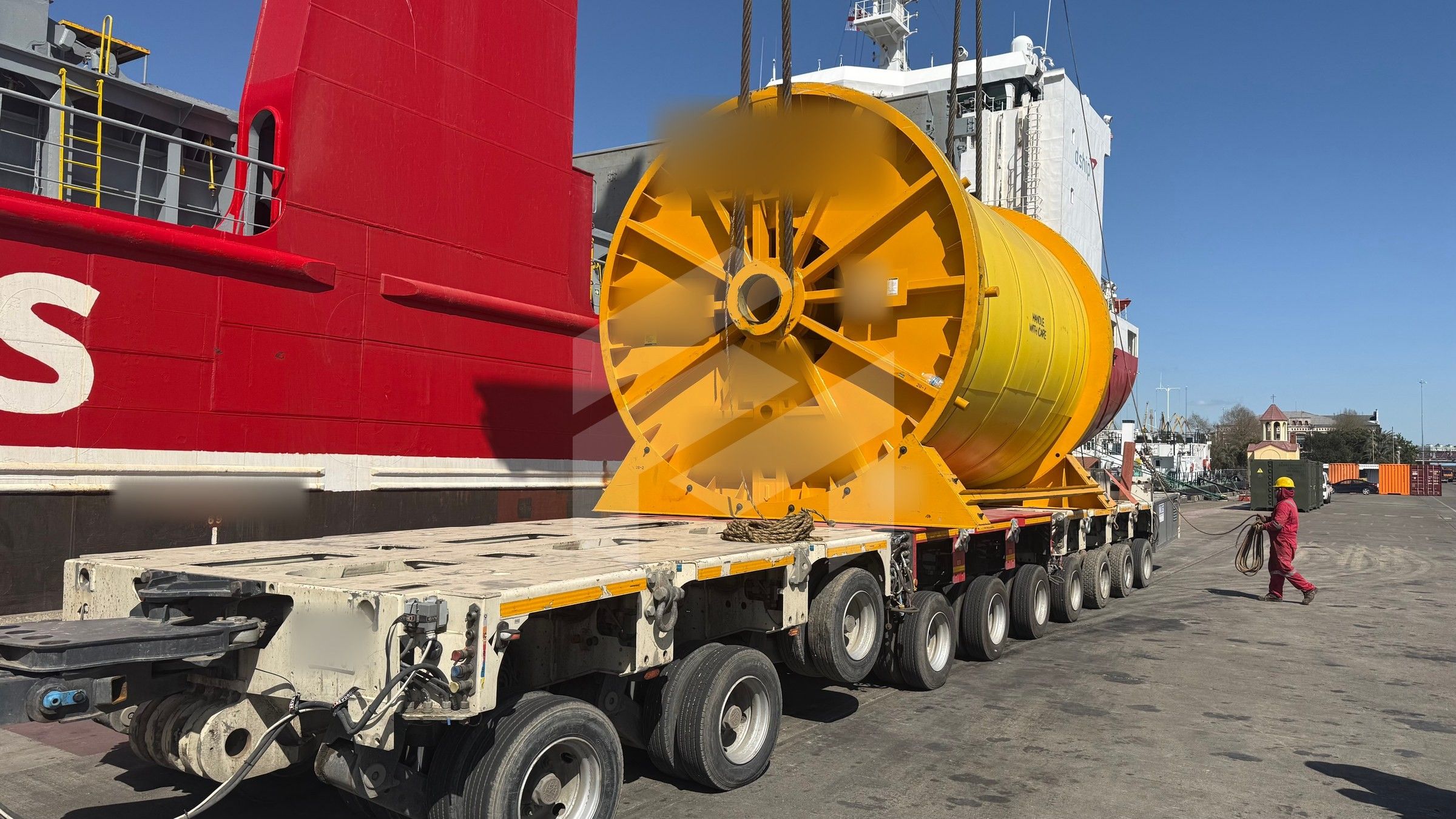 A 153 t anchor wire rope reel on a modular trailer beside the ship
